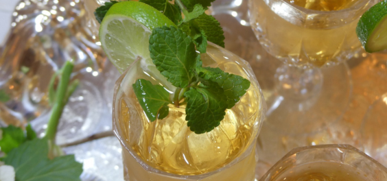 White iced tea in a glass with fresh herbs. 