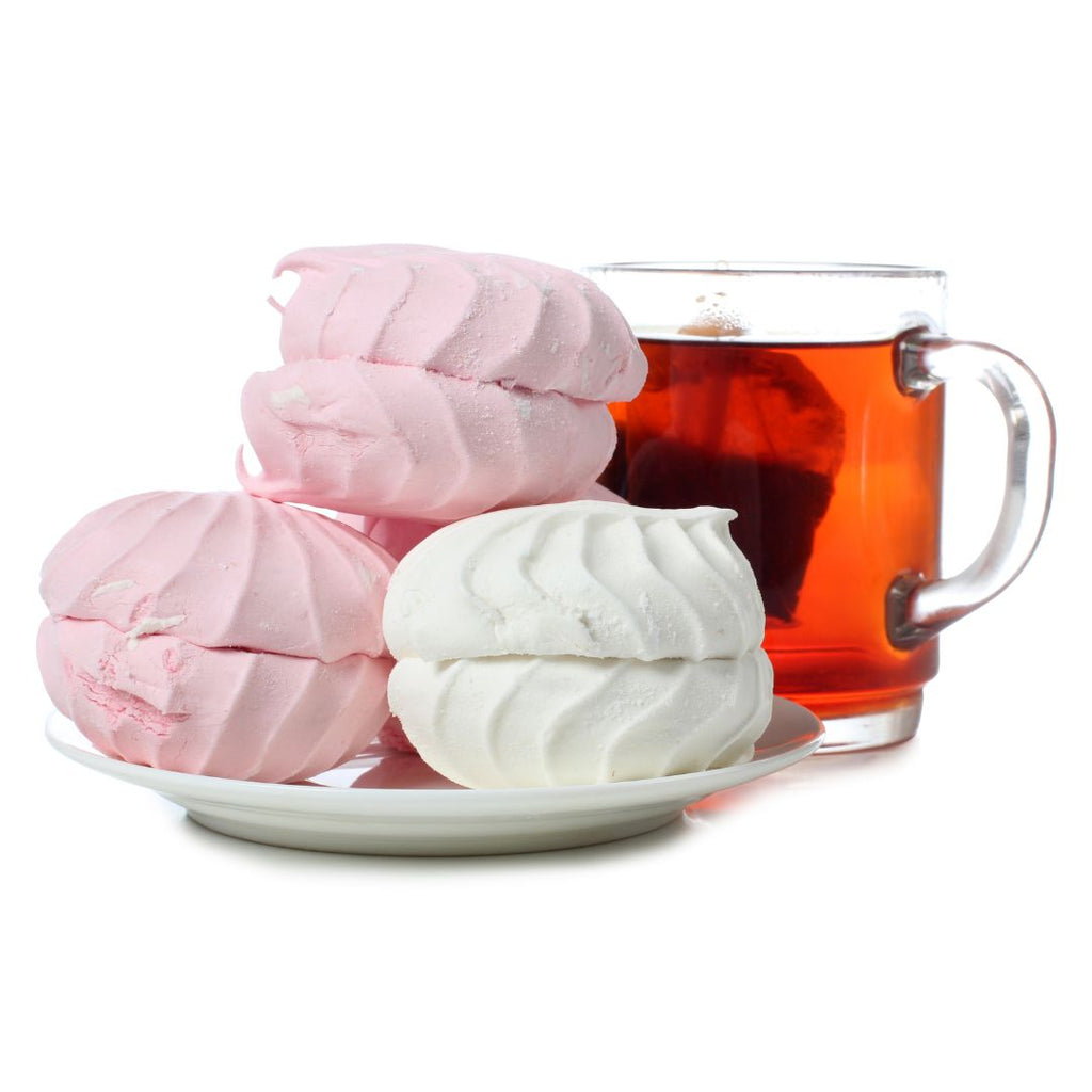 Pink and white macrons and a clear cup of hot tea